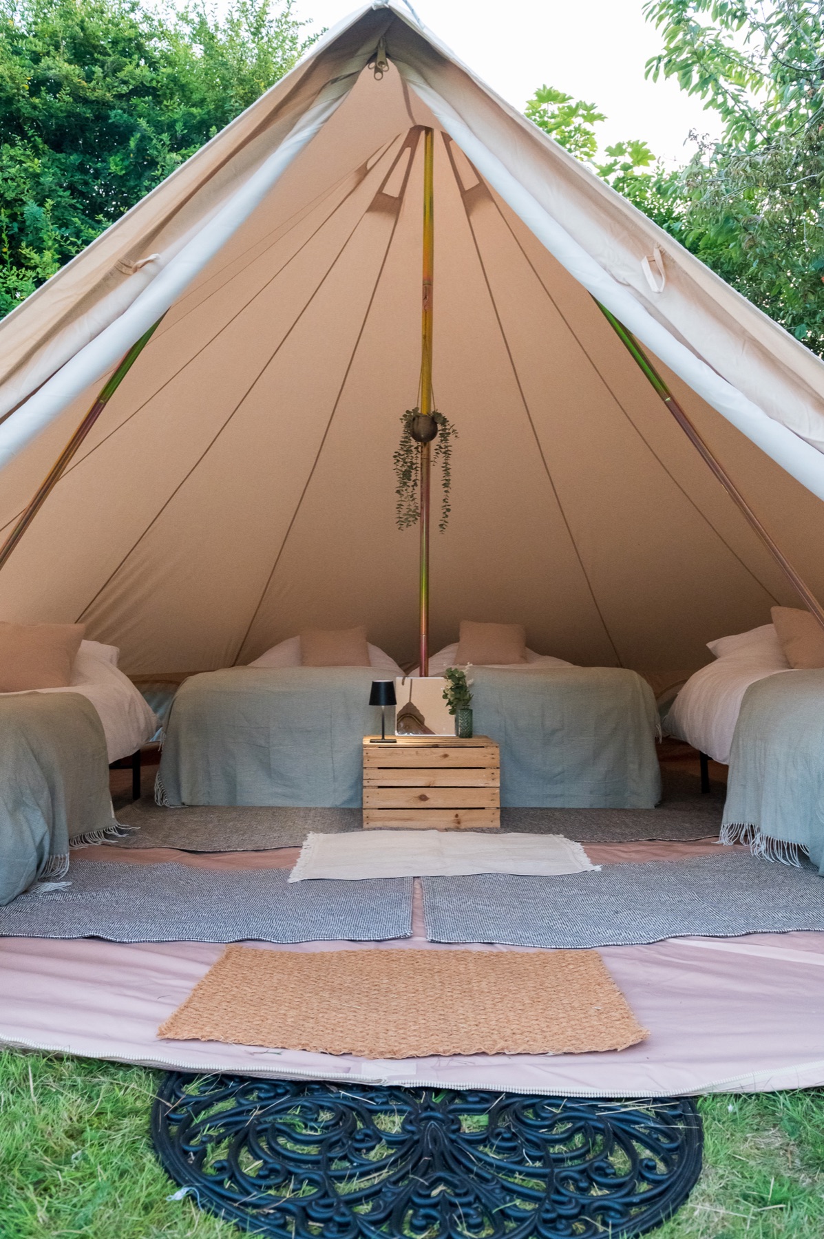 Hire beds made up with laundered white bedding in a bell tent